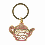 Teapot-shaped keychain with gold and pink design on a gold background, text, would rather have nothing but tea