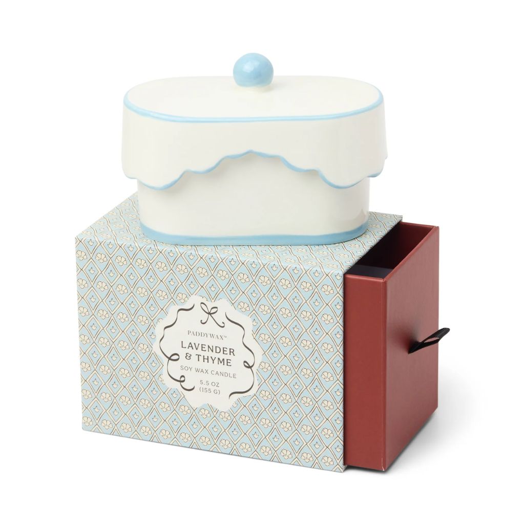 Candle in a decorative box with a blue lid on a white background