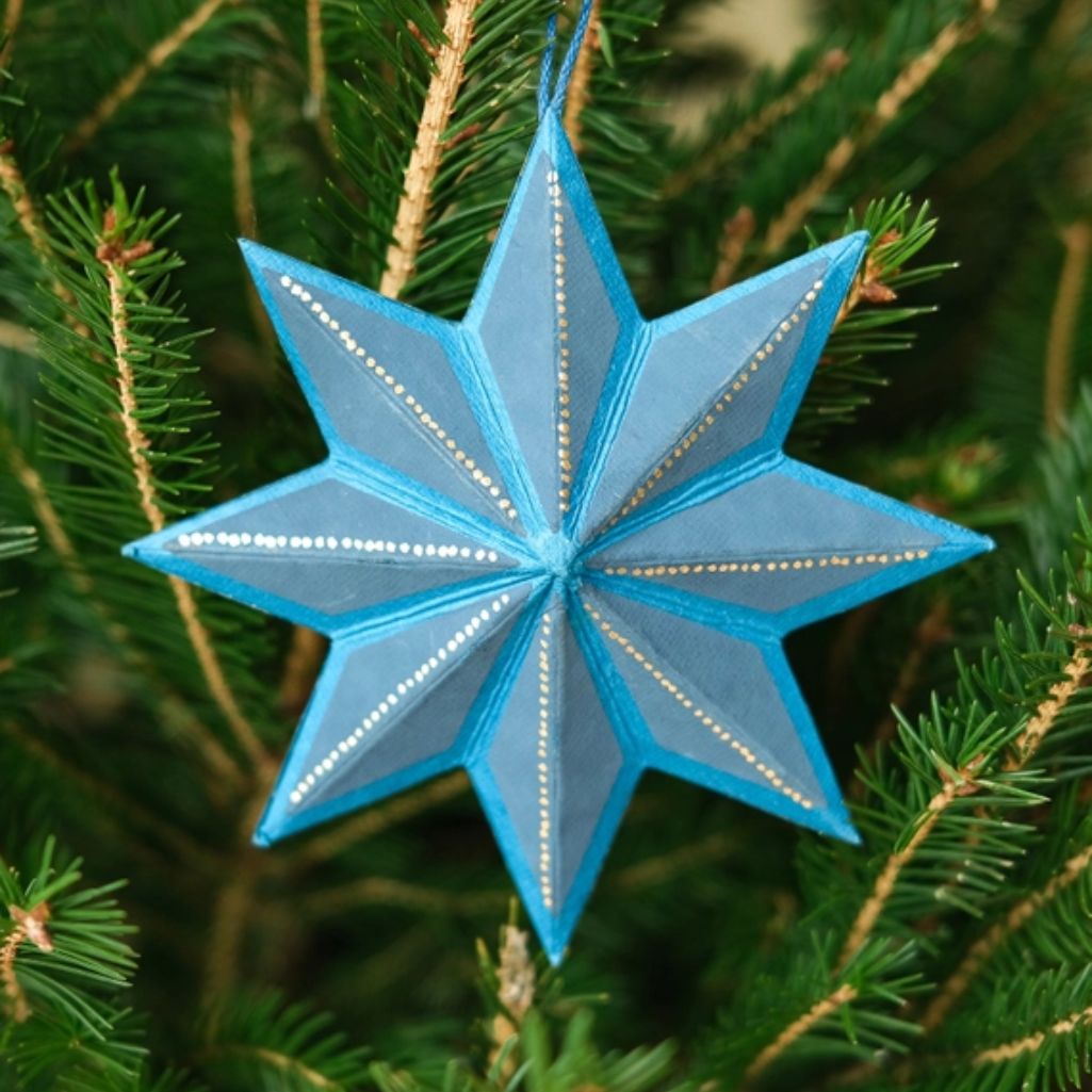Blue star-shaped ornament on a Christmas tree