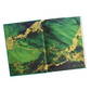 Open book with green and gold marble pattern on a white background