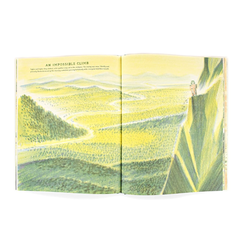 Illustrated book open to a landscape scene with a mountain and person on a path.