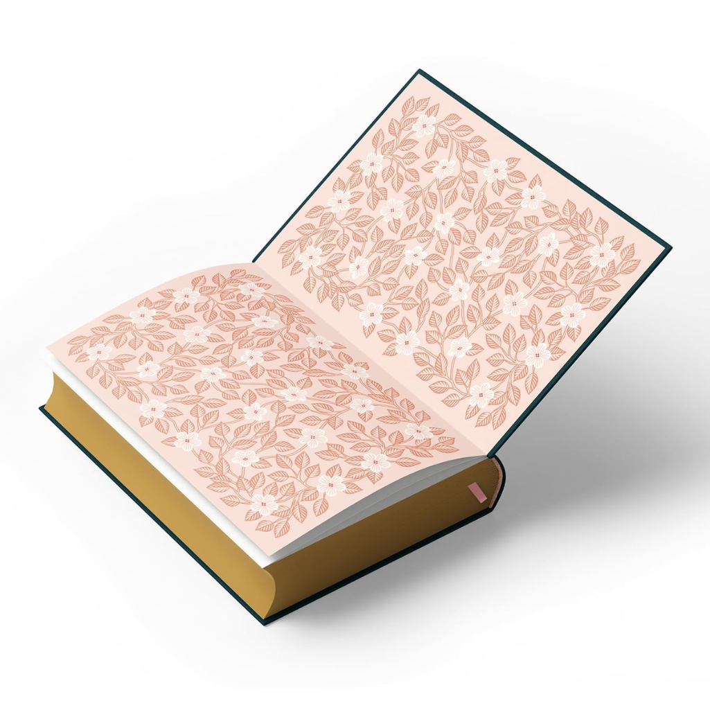 Open book with floral pattern on pages and gold binding on a white background