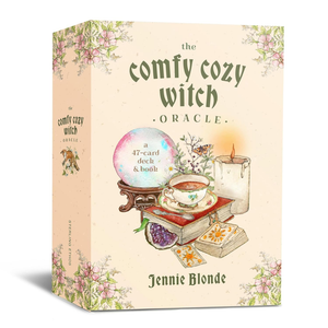 Box for 'The Comfy Cozy Witch Oracle' with illustrations of a crystal ball, tea cup, and books on a pastel background.
