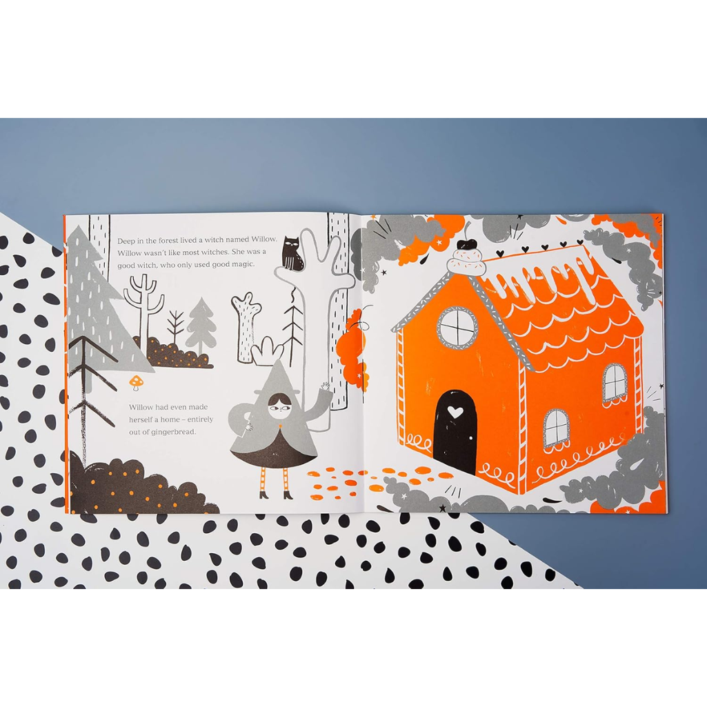 Illustrated book page with a gingerbread house and forest scene on a blue background