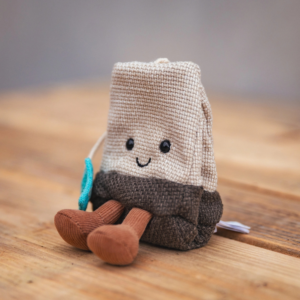 Jellycat Tea Bag plush sitting on a table, side