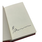 Open book with a signature on a white background