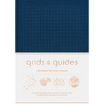 Notebook with grid design on cover and text 'grids & guides' on a white background