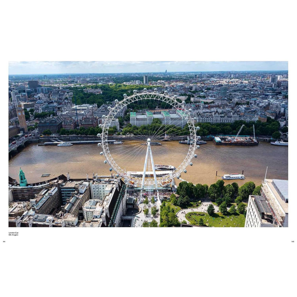 Aerial photograph of London featuring the London Eye prominently in the foreground, with the River Thames, city buildings, and green parks surrounding it. The photo is presented with a wide white border, suggesting it is a poster or art print.