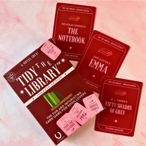 Card game packaging with book-themed cards on a pink background