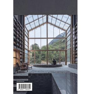 Modern architectural interior with large glass windows overlooking a mountainous landscape.