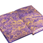 Purple and gold patterned fabric on a white background