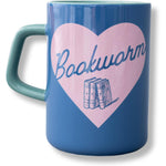 A blue ceramic mug with a teal handle and interior, featuring a large pink heart graphic on the front with the word 'Bookworm' in blue script and an illustration of three books.