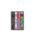 A slim leather card holder wallet featuring a vertical multicolor patterned design inspired by book spines, including black, lavender, red, green, and floral motifs, set against a light gray background.