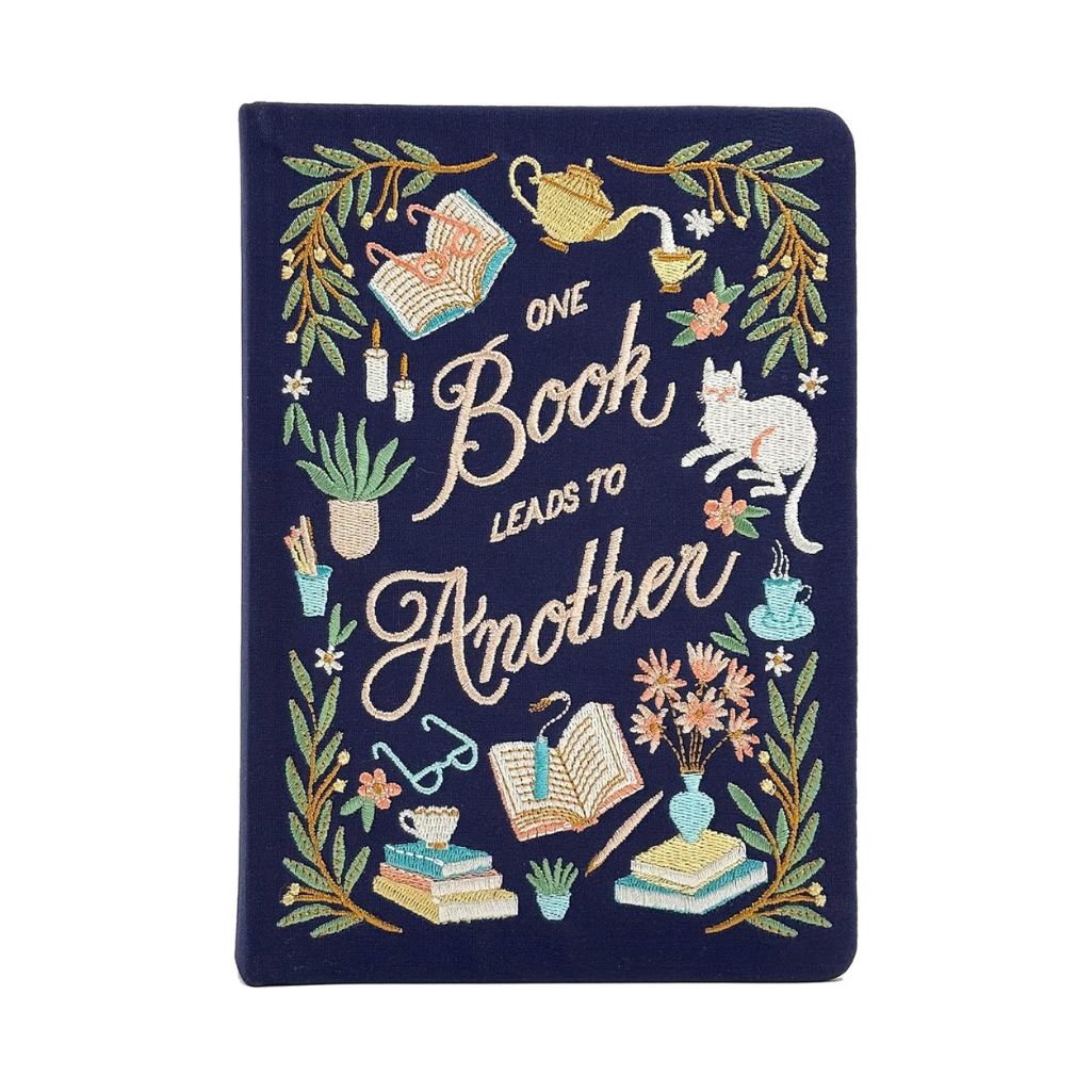 Decorative notebook with embroidered designs and text on a white background
