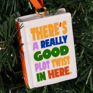 Decorative book ornament with colorful text on a green background