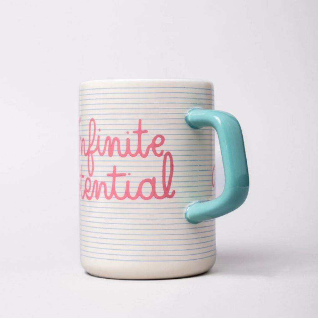 Mug with 'infinite potential' text and a turquoise handle on a light gray background