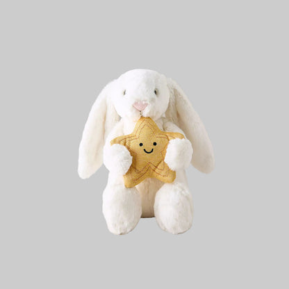 White plush bunny holding a gold star with a smiley face on a light gray background