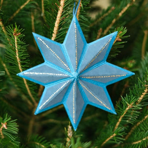 Blue star-shaped ornament on a Christmas tree