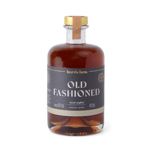 Bottle of 'Old Fashioned' cocktail mixer with a gold cap on a white background