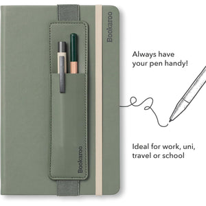A fern green Bookaroo notebook with a pen pocket holding two pens, shown on a white background with promotional text and a pen illustration. The notebook has a beige elastic closure band and the brand name 'Bookaroo' printed vertically on the cover and pocket.