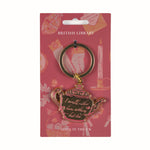 Teapot-shaped keychain with 'I would rather have nothing but tea' text on a pink British Library packaging.