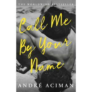 Book cover of 'Call Me By Your Name' by Andre Aciman with a black and white photo of two people on a beach.