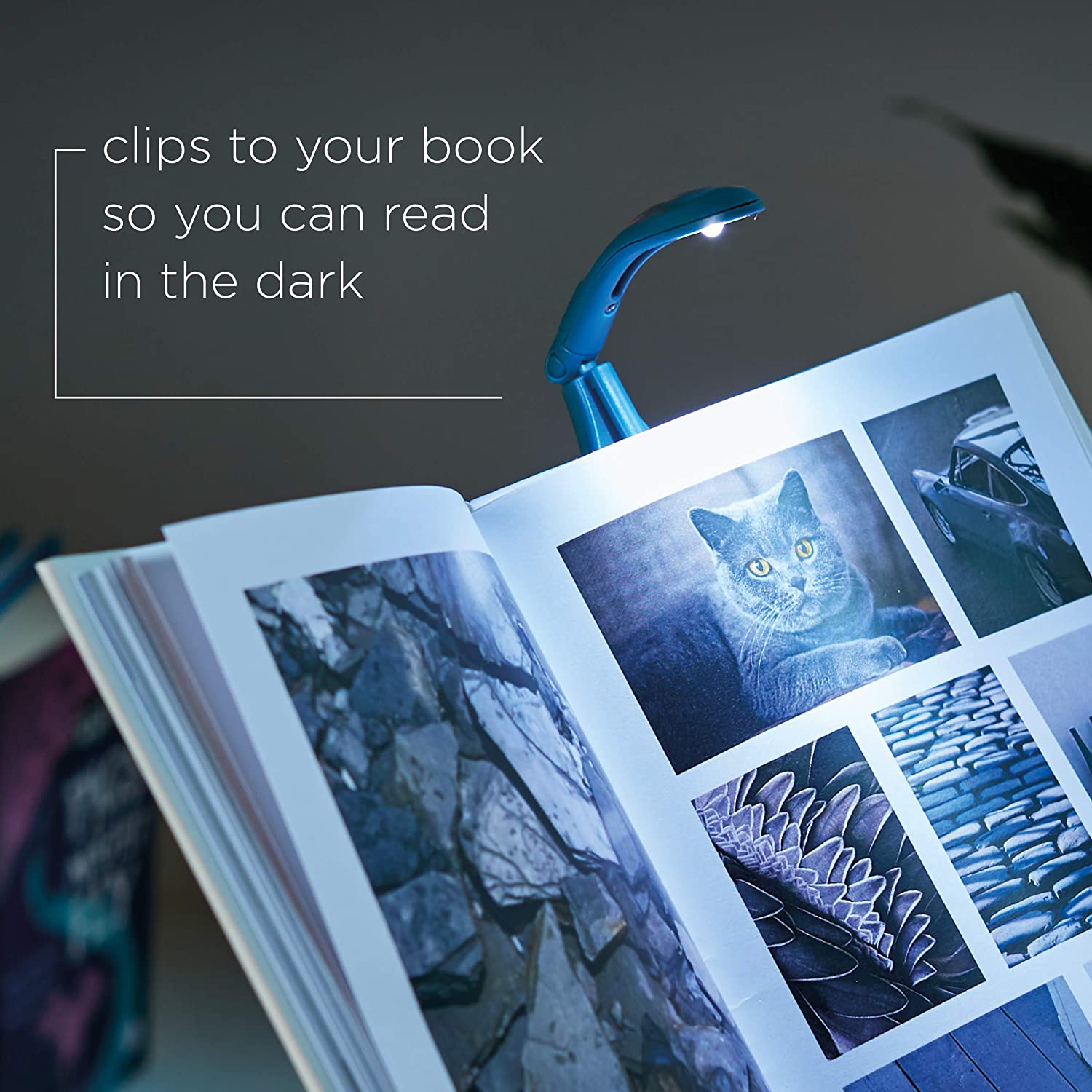 Navy Really Tiny Book Light shown turned on in a dark room illuminating a page of a book